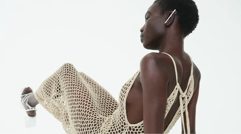 A model in a crochet dress wearing a SOOD ear cuff