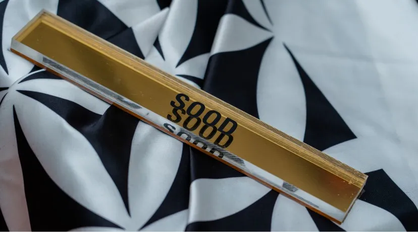 A gold SOOD piece on patterned silk